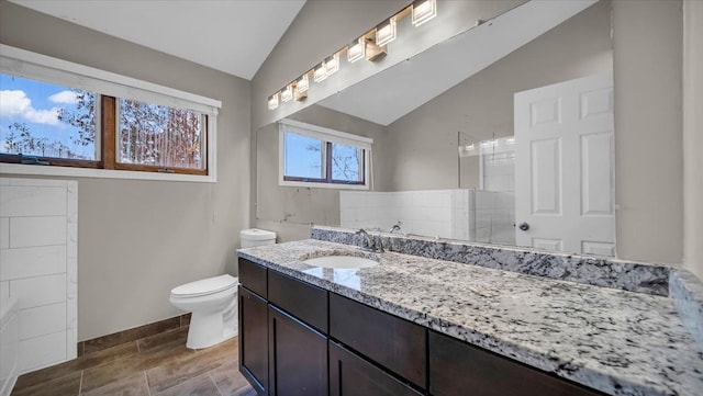 bathroom with vanity, vaulted ceiling, and toilet