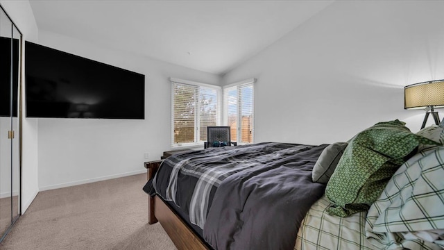 bedroom featuring carpet flooring, vaulted ceiling, and a closet