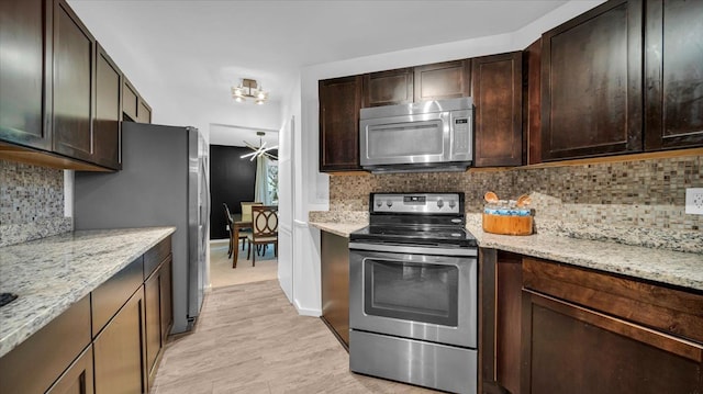 kitchen featuring decorative backsplash, appliances with stainless steel finishes, and light hardwood / wood-style flooring