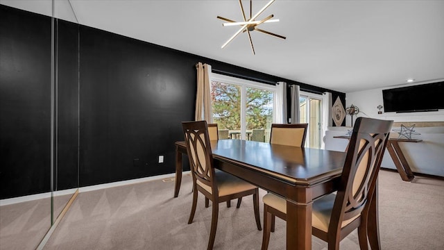 dining space featuring light carpet and a chandelier