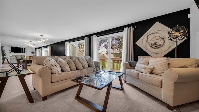 carpeted living room with an inviting chandelier