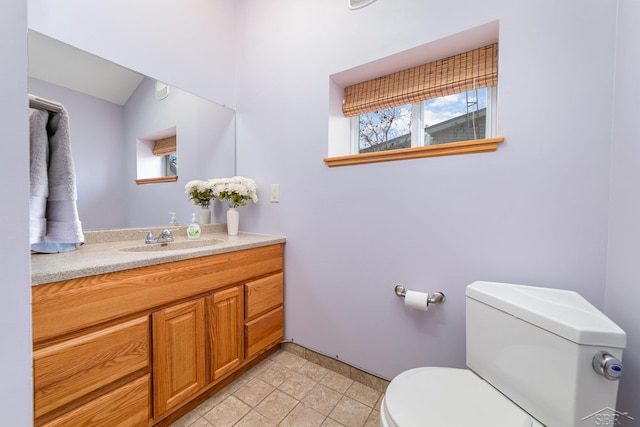 bathroom featuring tile patterned floors, vanity, toilet, and lofted ceiling