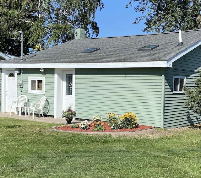 rear view of house featuring a yard