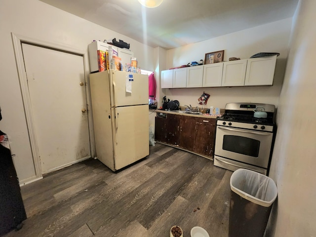 kitchen with white cabinets, dark hardwood / wood-style flooring, white refrigerator, and stainless steel gas range oven