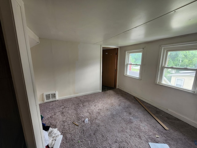 carpeted empty room with lofted ceiling