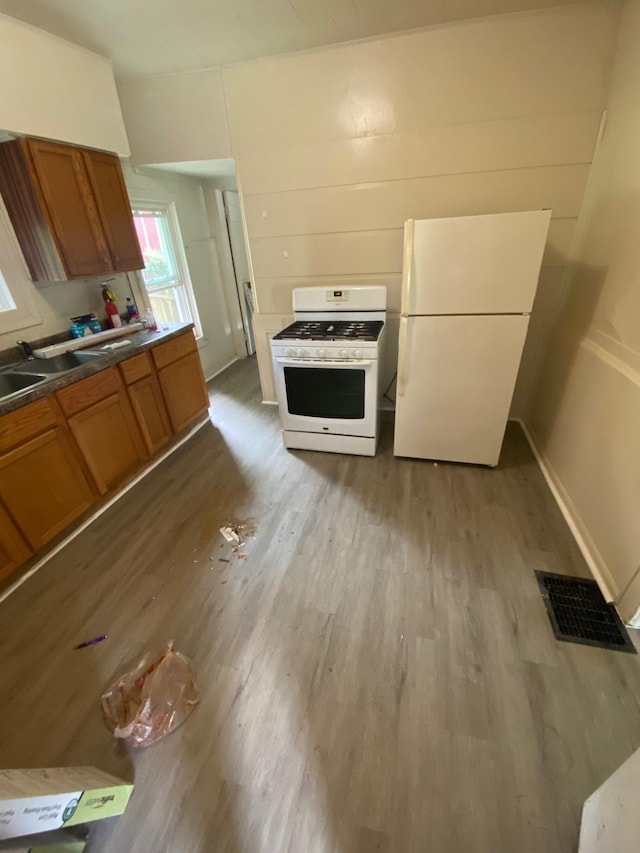 kitchen with white appliances and light hardwood / wood-style flooring