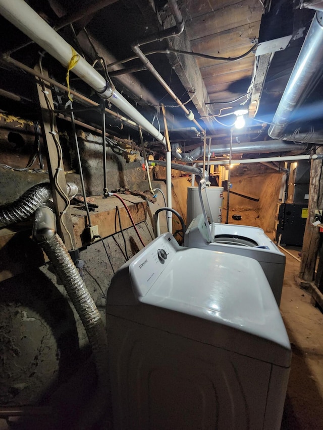 clothes washing area with washer and dryer and gas water heater