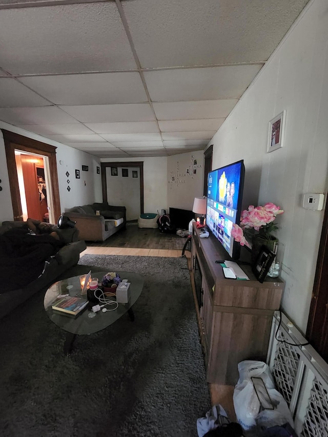 living room featuring hardwood / wood-style flooring and a drop ceiling