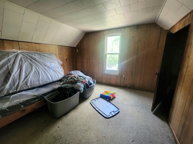 bonus room featuring carpet floors, wooden walls, and lofted ceiling