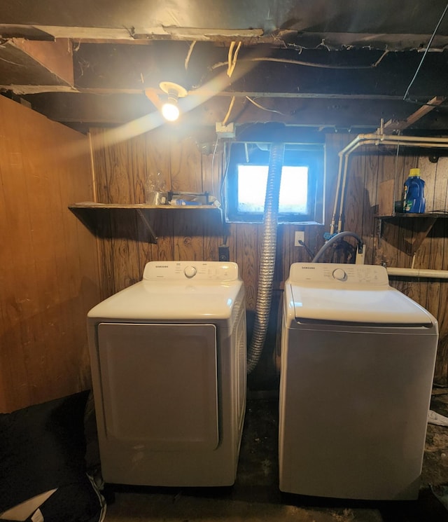 washroom with wood walls and independent washer and dryer