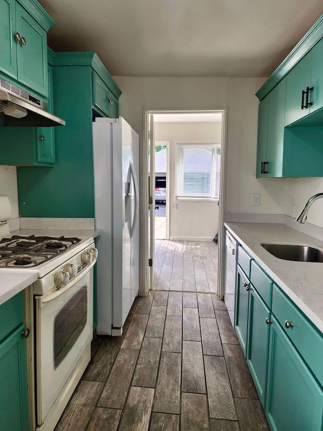 kitchen with white appliances, dark hardwood / wood-style floors, green cabinets, and sink