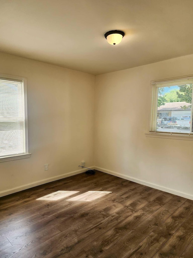 unfurnished room with dark hardwood / wood-style flooring