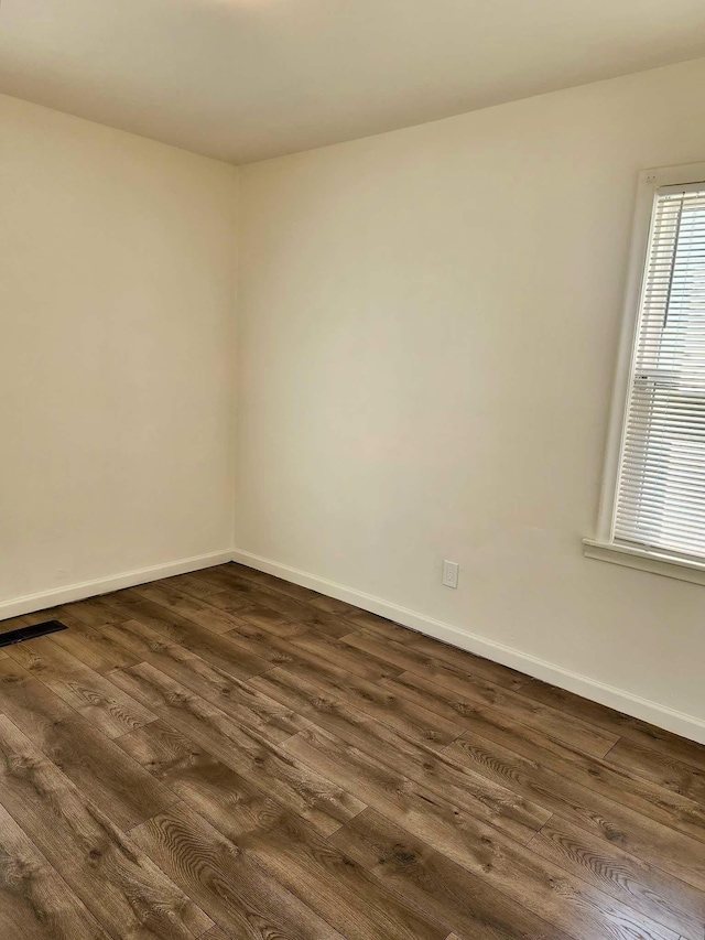 unfurnished room with dark hardwood / wood-style flooring