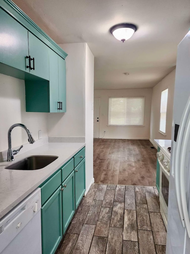 kitchen with dark hardwood / wood-style flooring, white appliances, and sink