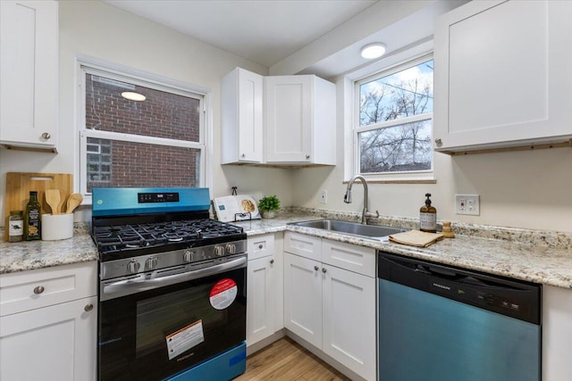 11059 Lakepointe St, Detroit, MI 48224 - kitchen featuring light stone countertops, sink, stainless steel appliances, light hardwood / wood-style floors, and white cabinets