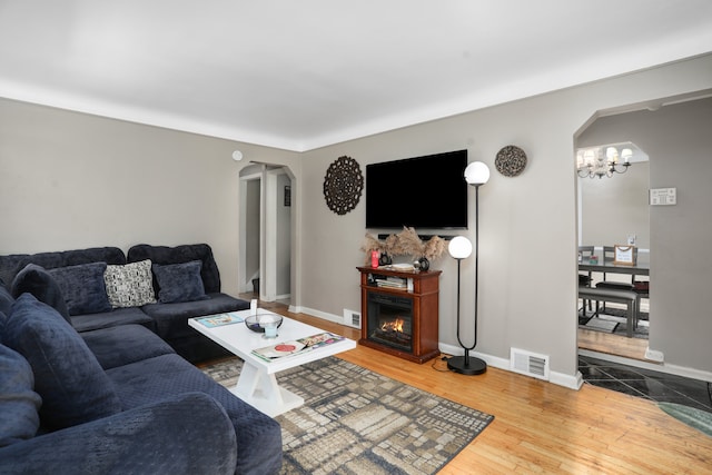 living room with hardwood / wood-style floors and an inviting chandelier