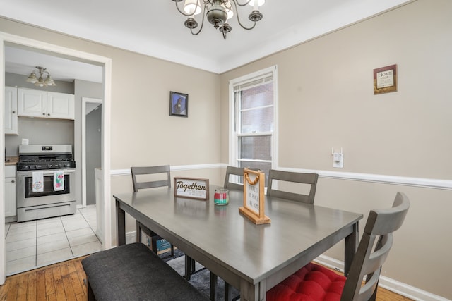 dining room with light wood-type flooring and a notable chandelier