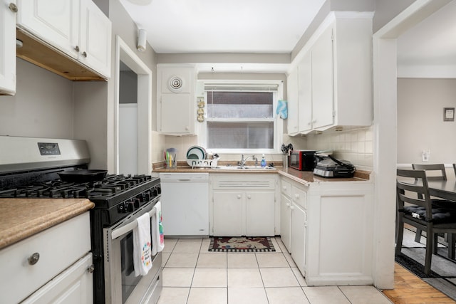 kitchen featuring backsplash, white dishwasher, sink, white cabinets, and stainless steel gas stove