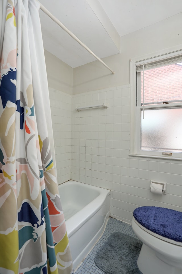 bathroom featuring shower / bathtub combination with curtain, tile patterned floors, and tile walls