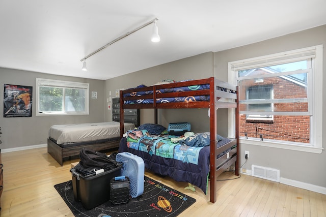 bedroom featuring light hardwood / wood-style flooring and track lighting