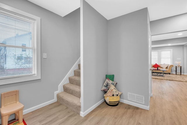 stairs featuring hardwood / wood-style floors