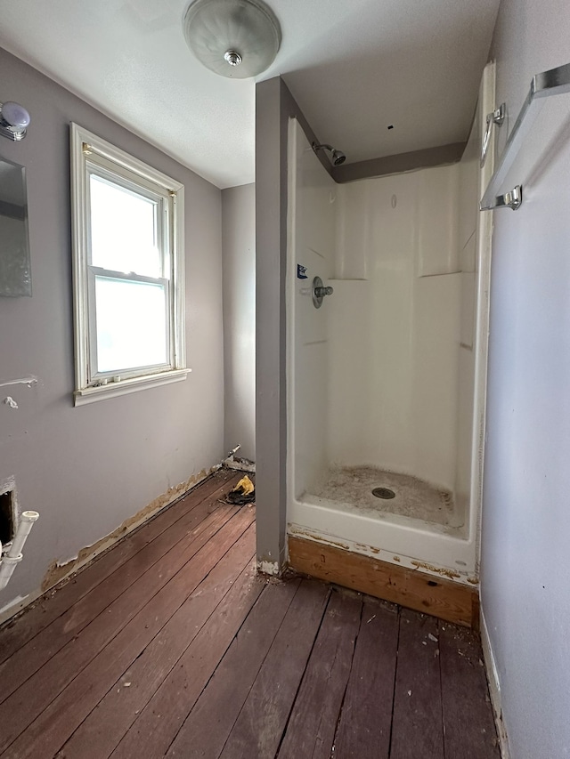 bathroom featuring hardwood / wood-style flooring and walk in shower