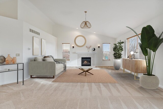 carpeted living room featuring a high end fireplace and lofted ceiling