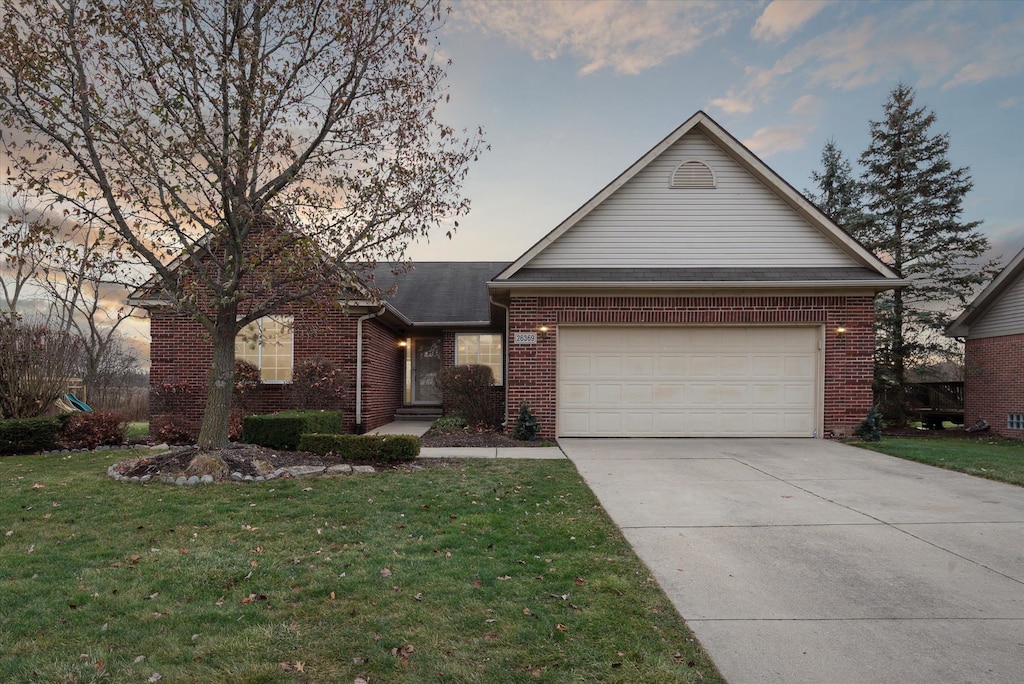 view of front of home with a yard and a garage