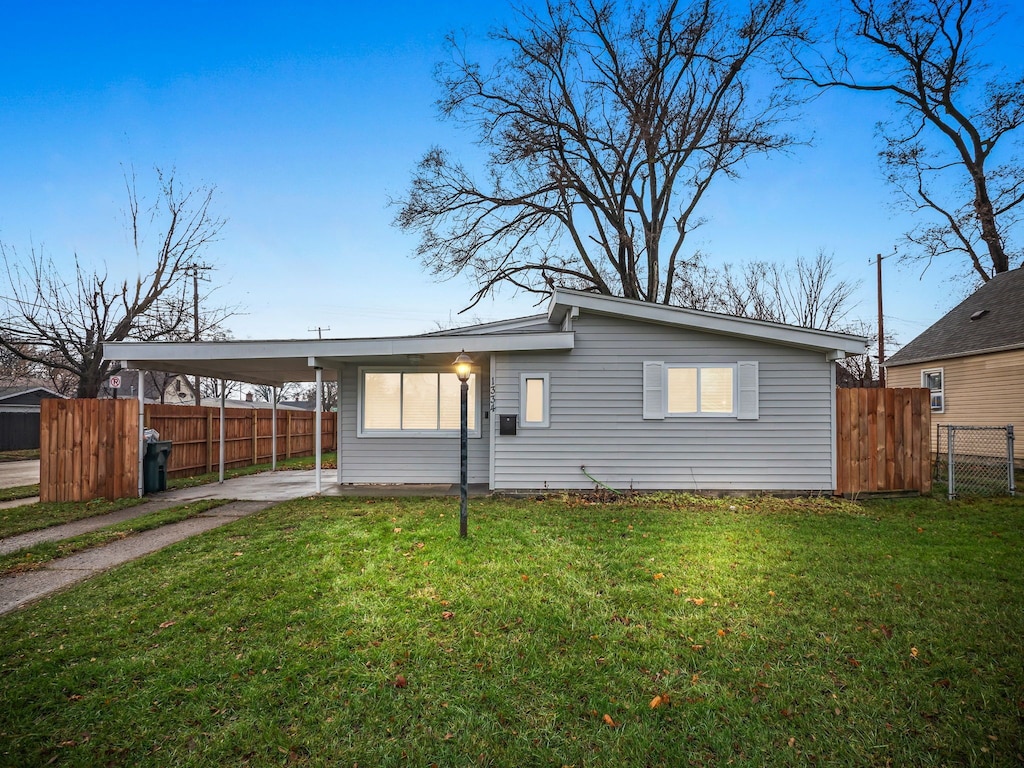 back of property featuring a carport and a yard