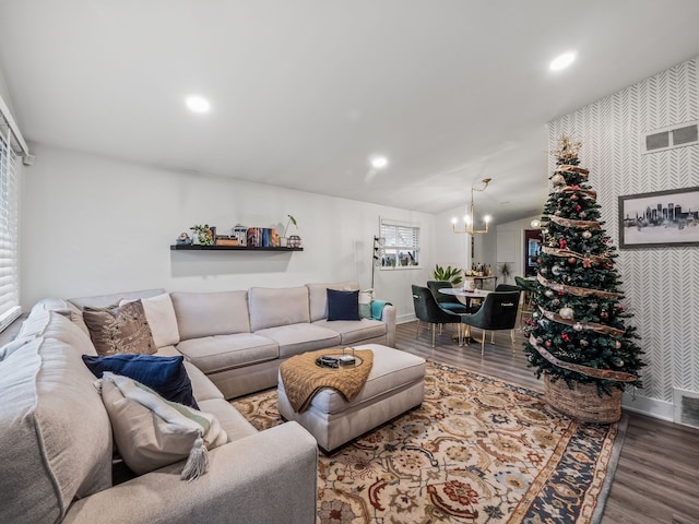 living room with an inviting chandelier, vaulted ceiling, and hardwood / wood-style flooring