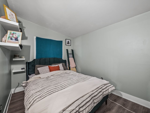 bedroom with lofted ceiling and dark hardwood / wood-style floors