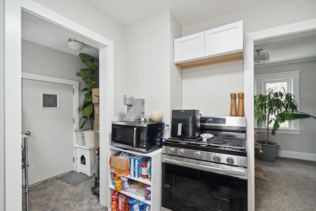 kitchen featuring white cabinetry, dark colored carpet, and appliances with stainless steel finishes