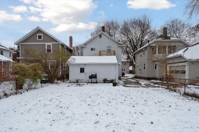 snow covered rear of property with a balcony