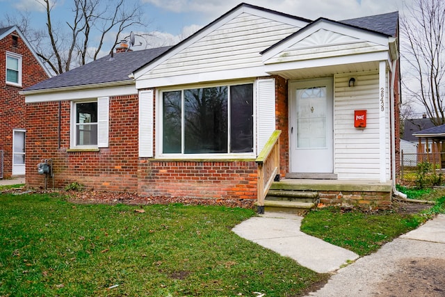 bungalow-style home with a front lawn