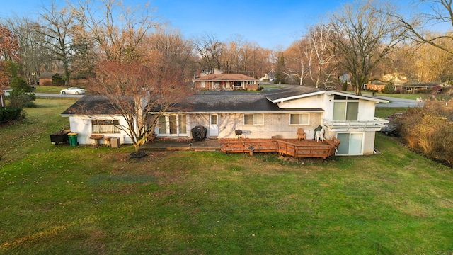 back of property with a yard and a wooden deck