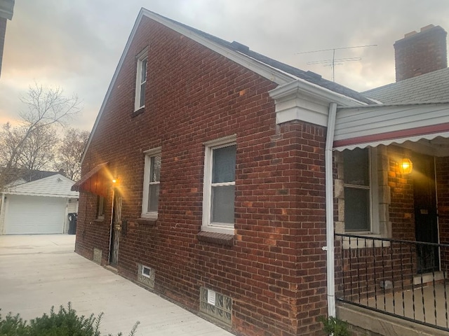 property exterior at dusk featuring an outbuilding and a garage