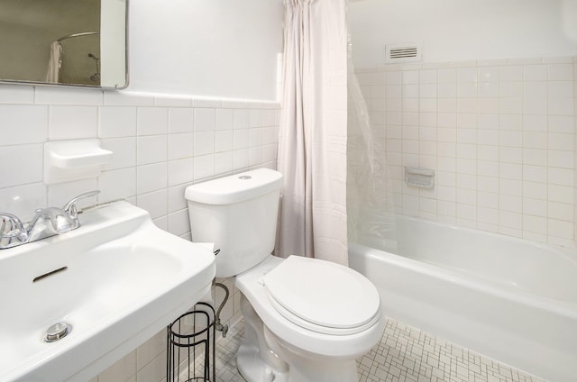 full bathroom featuring toilet, tile walls, and shower / bath combo with shower curtain