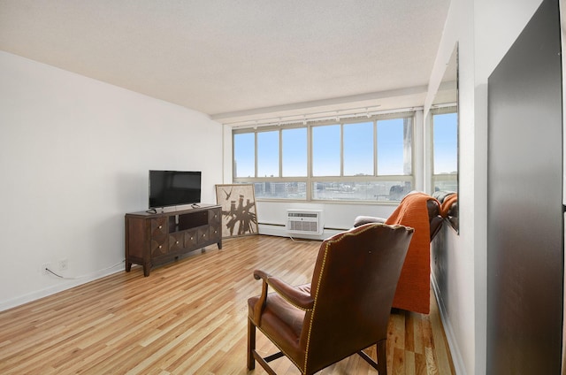 living room featuring a wall mounted air conditioner, light wood-type flooring, and plenty of natural light