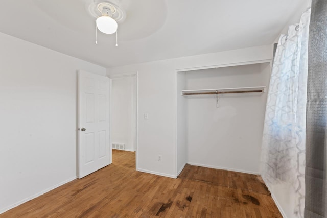 6058 Meadowwood Ln, Grand Blanc, MI 48439 - unfurnished bedroom featuring ceiling fan, a closet, and wood-type flooring