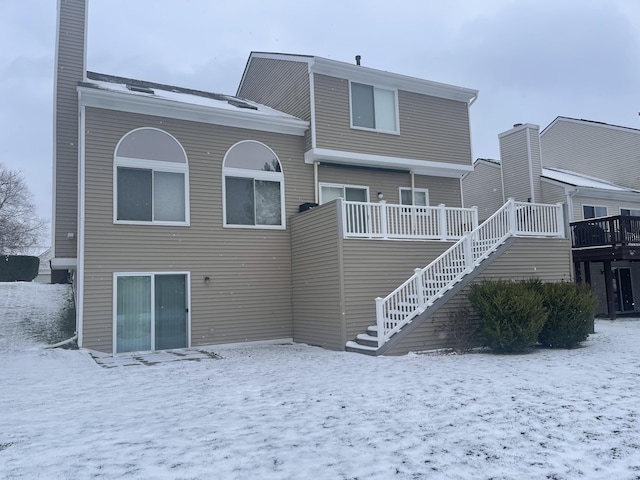 view of snow covered back of property