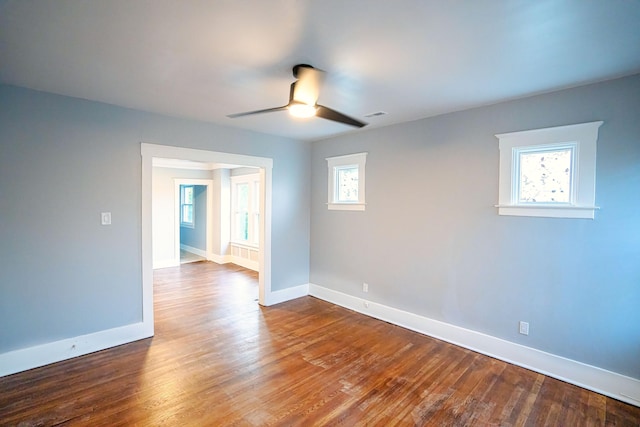 spare room with ceiling fan, hardwood / wood-style floors, and a healthy amount of sunlight