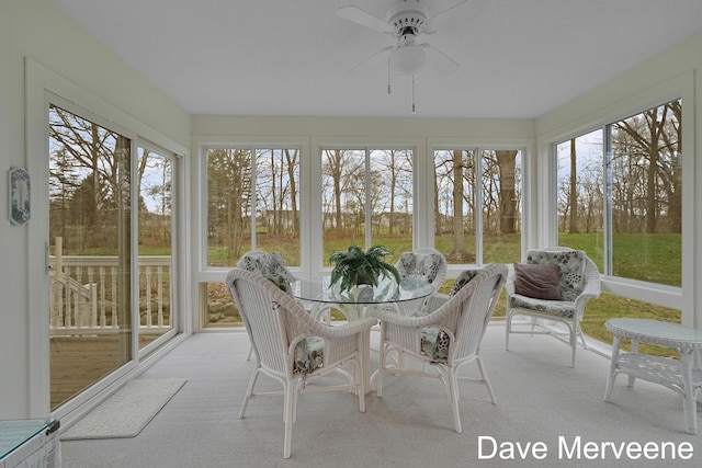 unfurnished sunroom with ceiling fan