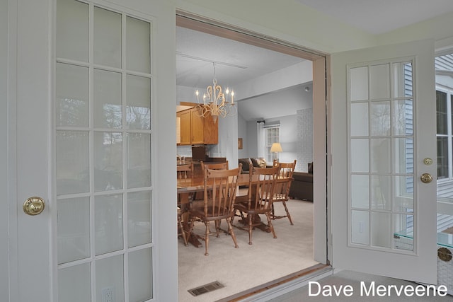 dining area featuring carpet and a notable chandelier