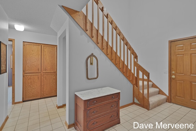 entrance foyer featuring light tile patterned floors and a textured ceiling