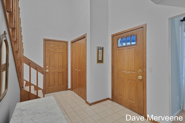 foyer with a towering ceiling and light tile patterned flooring