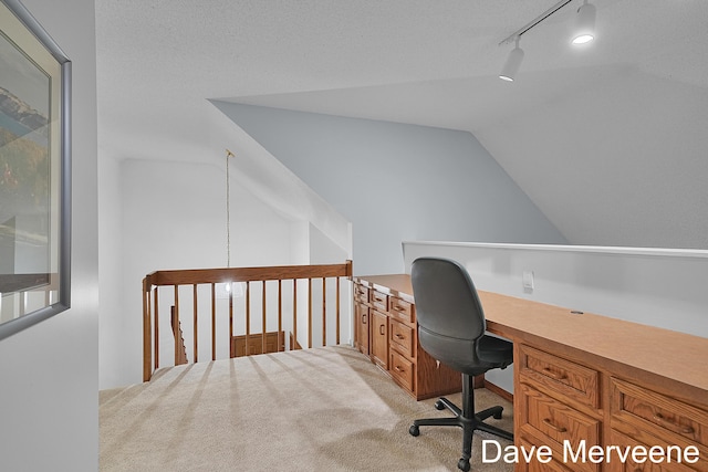 office with a textured ceiling, light carpet, track lighting, and lofted ceiling