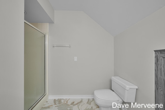 bathroom featuring toilet, a shower with shower door, and lofted ceiling