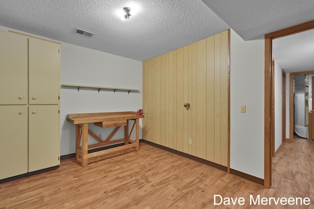 interior space featuring a closet, a textured ceiling, and light hardwood / wood-style flooring