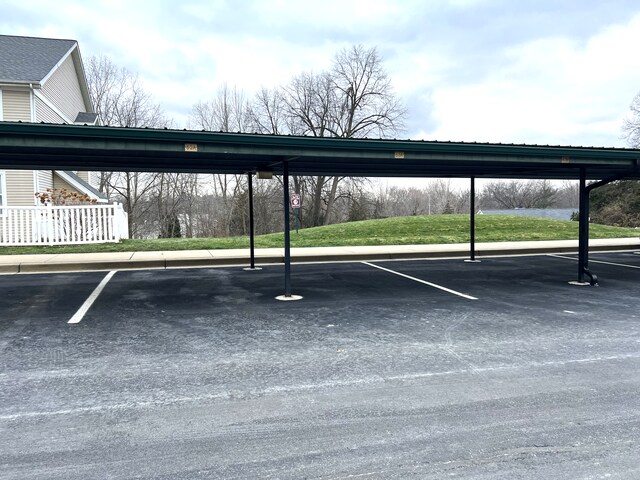 view of parking / parking lot featuring a carport and a yard