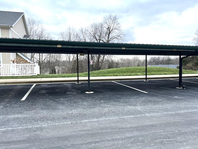 view of vehicle parking featuring a carport and a lawn